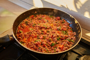 Spaghetti bolognese sauce being fried on a pan