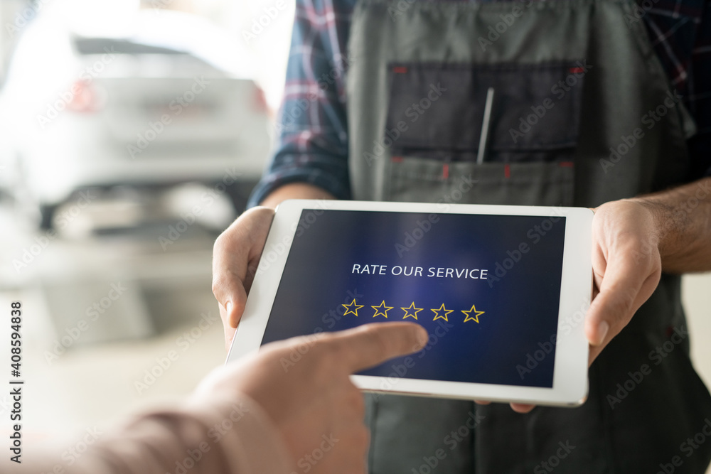 Poster technician holding tablet with five stars on screen while client rating service