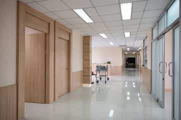 Empty hospital corridor with various rooms and trolley patient service