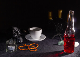 A bottle of red liquid like blood, a Cup of coffee grounds for predictions. Magical potion. The concept of wizards, witchcraft and magic. Halloween.