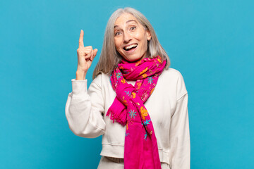 middle age woman feeling like a happy and excited genius after realizing an idea, cheerfully...