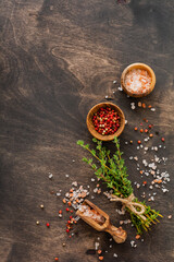 Food cooking background. Spices herbs bunch thyme and seasoning salt and pepper at black slate...
