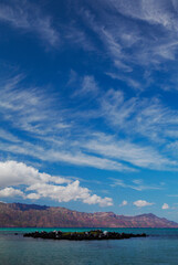 Vertical view of beautiful clouds and turquoise waters in the Sea of Cortez at Coronado Beach in Loreto, Mexico
