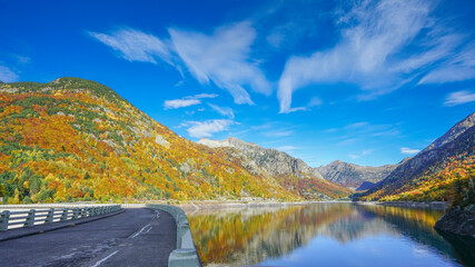 The road on the dam of Baserca Reservoire during autumn , Spain