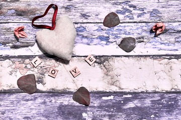 Fabric heart, word love in pieces of wood on antique wood background and space to write greetings or Valentine's Day.