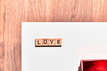 Word love on wooden pieces on white background and wood with copy space for greetings or Valentine's Day.