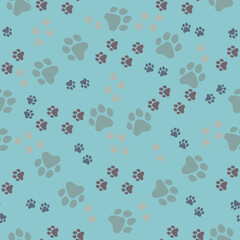 Cat footprints, small and large on a light blue background. Seamless pattern.