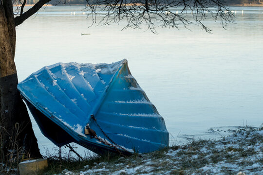 boat on a shore of a lake covered with ice