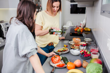 Women preparing healthy food in kitchen having fun, concept dieting nutrition.