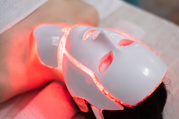 Woman is wearing cosmetic face photon mask. Health and beauty. Cosmetic procedure for woman face....