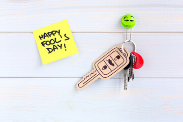 Key ring hung on the wall with a car key made of cardboard as a joke for the celebration of Fool's...