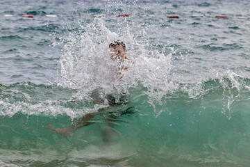 Fototapeta premium The guy bathes in the sea. Big waves