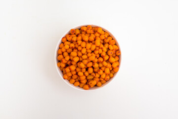 Bowl with sea buckthorn berries on a white background. View from above.