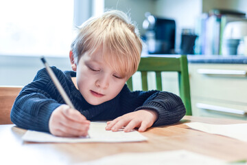 Child doing homework at the kitchen table at home during lockdown