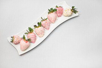 Fototapeta na wymiar White Curve Rectangle Plate Full of Strawberry Covered Chocolate on White Fabric Background.
