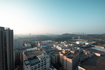 Obraz premium Morning in Guangzhou, China There are small and tall houses and cars on the road below. Mountains in the background. Roofs of the houses