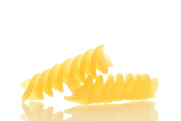 Bright yellow uncooked Fusilli pasta, close-up, isolated on white.