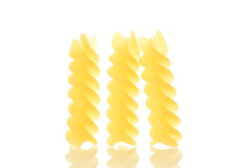 Bright yellow uncooked Fusilli pasta, close-up, isolated on white.