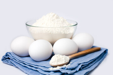 Fototapeta na wymiar Dough preparation. Flour and eggs on the white background. Close-up.