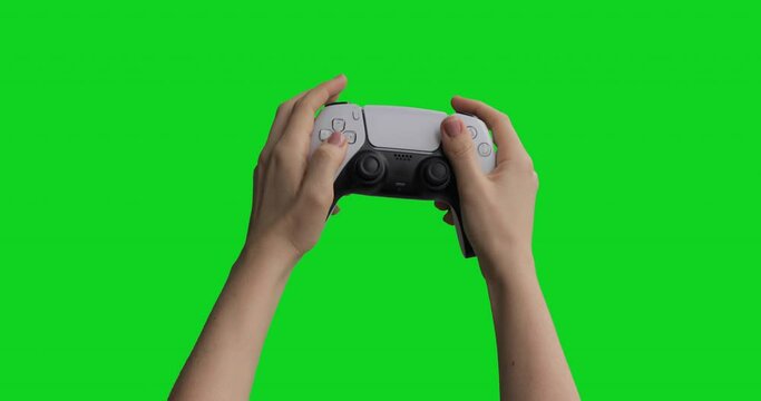 Teenager using gamepad wireless controller pressing keys and sticks and playing competitive action shooter console games. Isolated chroma key background.
