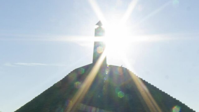 Zoom in - Time lapse of sun appearing behind obelisk on Austerlitz Pyramid. The Piramide van Austerlitz is a monument built in 1804 as a tribute to Napoleon Bonaparte.