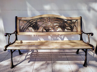 wooden bench with forged metal legs on a sunny day