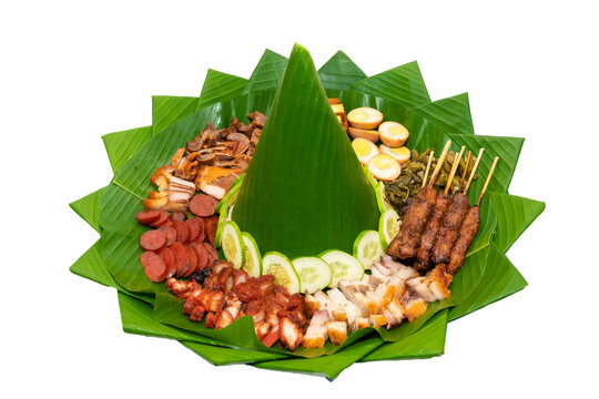Various kinds of pork dishes including pork satay, pork sausage and roasted pork belly, served in traditional Indonesian tumpeng