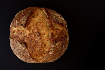Homemade sourdough bread, isolated on black background, top view.