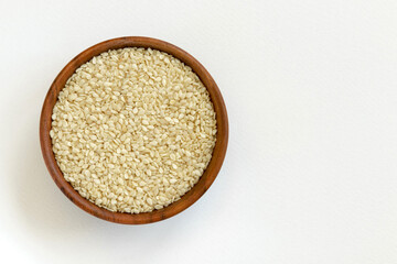 Fototapeta na wymiar Wooden bowl of sesame seeds isolated on white background