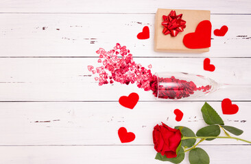 Red hearts flow out of champagne glass, gift box and rose