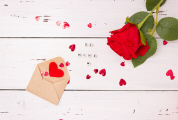 Red hearts, open letter envelope made of kraft paper and one rose