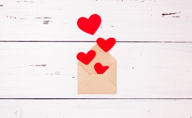 Red hearts and an open letter envelope made of kraft paper