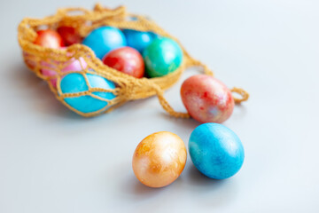 Several multi colored eggs in a knitted bag