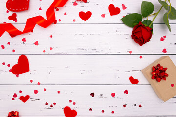 Gift, rose and red hearts on wooden background