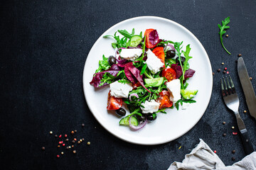 Greek salad vegetables and feta cheese portion on the table for healthy meal snack outdoor top view copy space for text food background rustic image keto or paleo diet