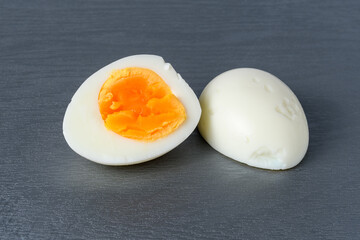 chicken egg hard boiled and cut in half on a gray cutting board close-up