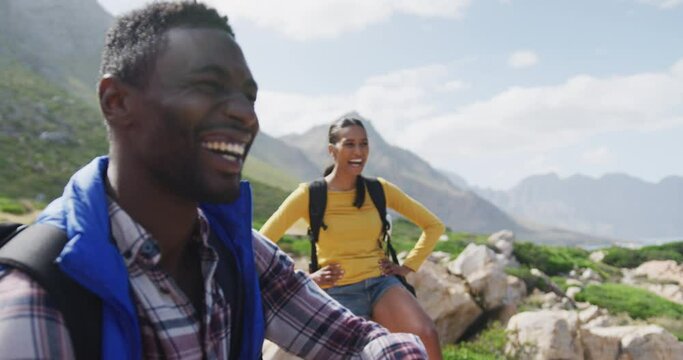 African american couple smiling and enjoying the view while hiking