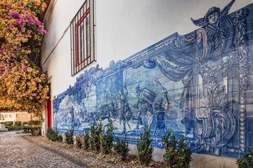 A wall of a traditional Portuguese house in Lisbon decorated by blue azulejo tiles showing the battle scene. No people - obrazy, fototapety, plakaty