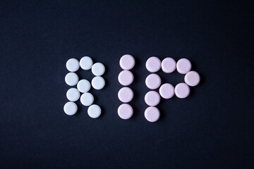 PASTILLAS CON LETRERO RIP SOBRE FONDO NEGRO