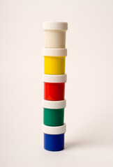 baby cans with gouache paint standing in one column on a white background