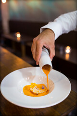 Chef serving salmorejo on plate