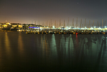 Amazing night view of a lot of boats and yachts at Howth harbor, Dublin, Ireland. Colorful lights spectacle with reflection in water