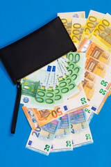 20, 50, 100, 200 Euro banknotes in a black leather wallet close-up. The concept of cash, cash savings, prosperity. Euromoney