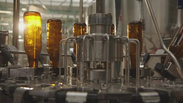 Washing process of empty beer brown bottles in a factory. Modern industrial machines in a brewery. Factory, brewery concept.