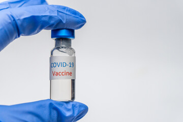 Bottle with vaccine against covid 19  in hand of researcher wearing gloves. Vial with coronavirus vaccine developed for protection against COVID-19. Healthcare and medical concept.