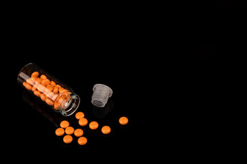 One glass jar of yellow Valerian pills on black background