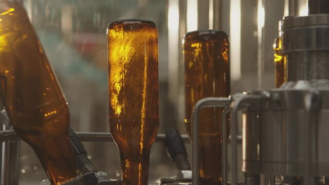 Close-up of bottles on a modern bottle washing machine. Modern technology machine in a factory. Process of bottle washing in a brewery. Factory concept.