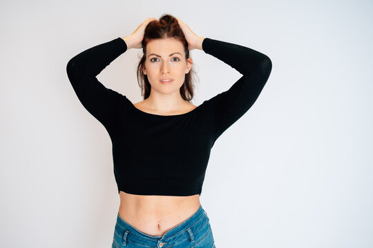 Frau mit braunen Haaren schwarzem Top Bauchrei blaue Jeans freundlich nett sedcard studio wei&szlig;er hintergrund