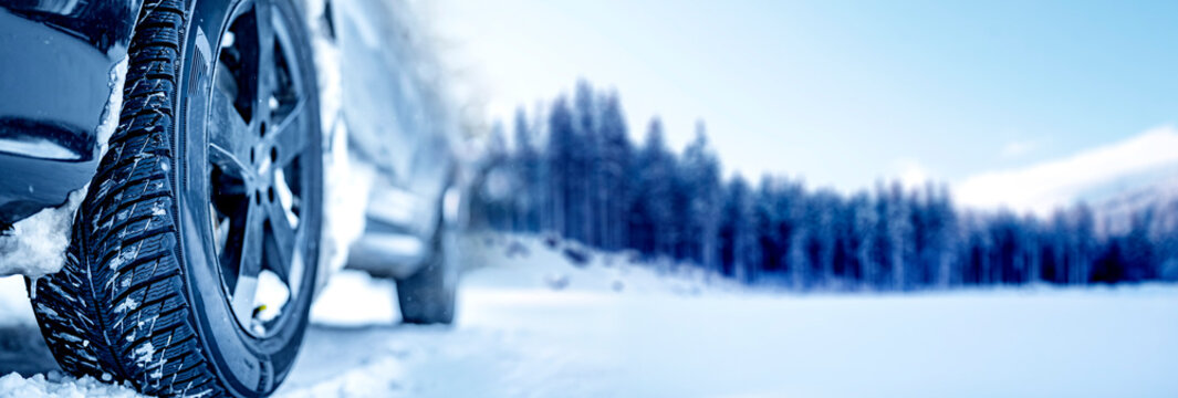 Winter tire. Detail of car tires in winter on the road covered with snow. Panorama, banner..