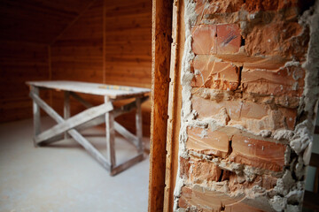 Interior view of house under construction, brick, wooden wall. Concept of reconstruction, repair.